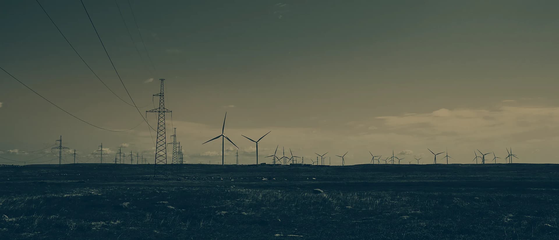 Panorama mit Windrädern und Stromtrassen in der Dämmerung